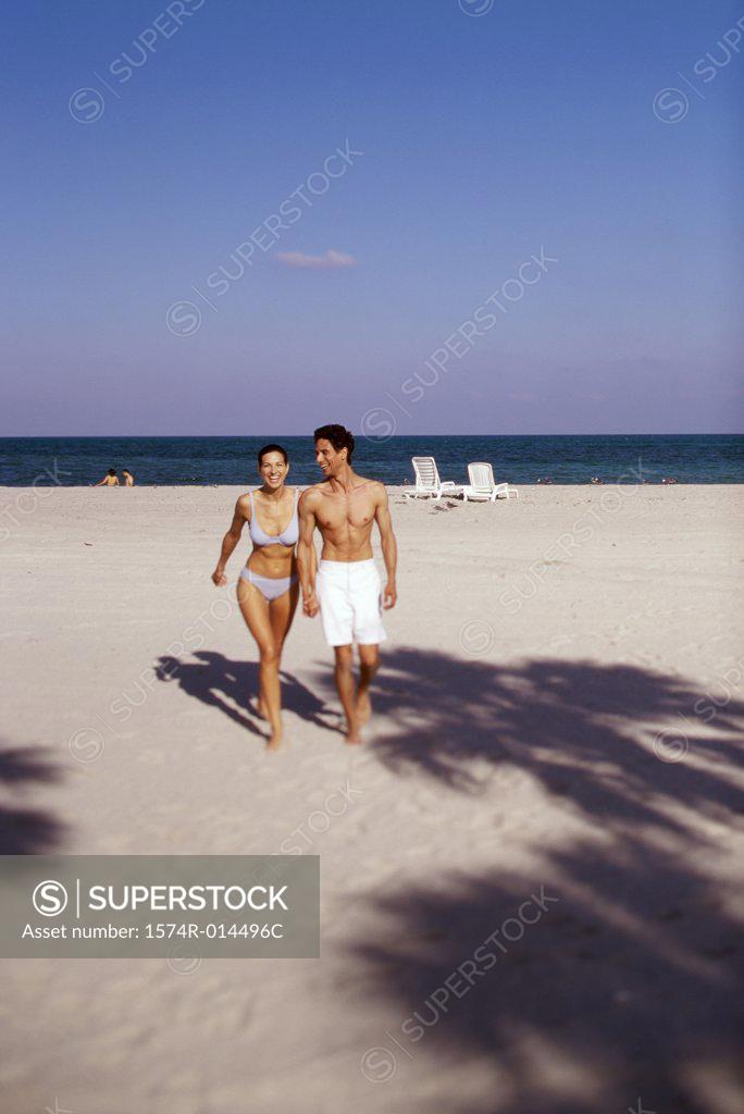 Stock Photo: 1574R-014496C Young couple walking on the beach