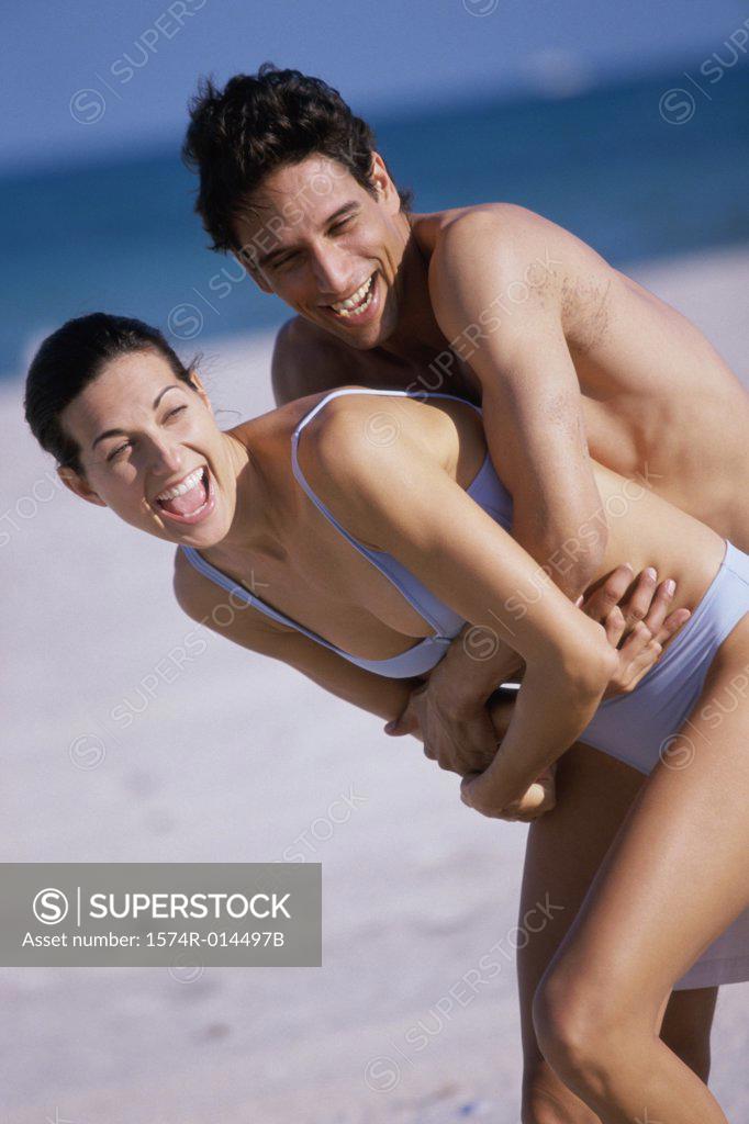 Stock Photo: 1574R-014497B Side profile of a young man embracing a young woman from behind