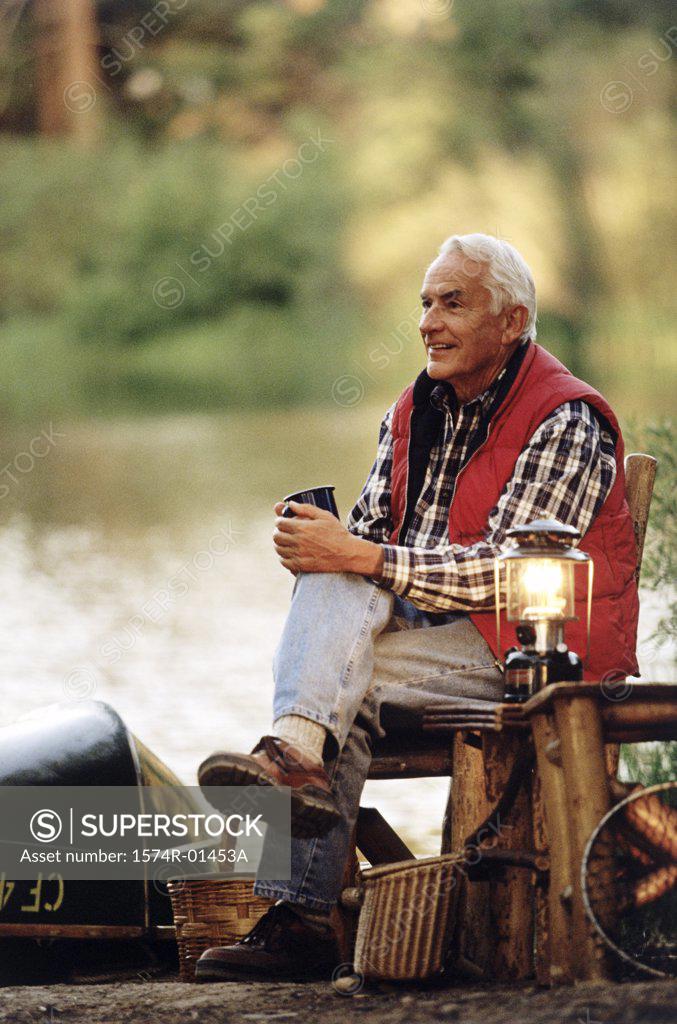 Stock Photo: 1574R-01453A Senior man sitting outdoors on a chair