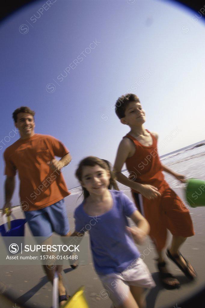 Stock Photo: 1574R-014548B Father with his son and daughter running on the beach