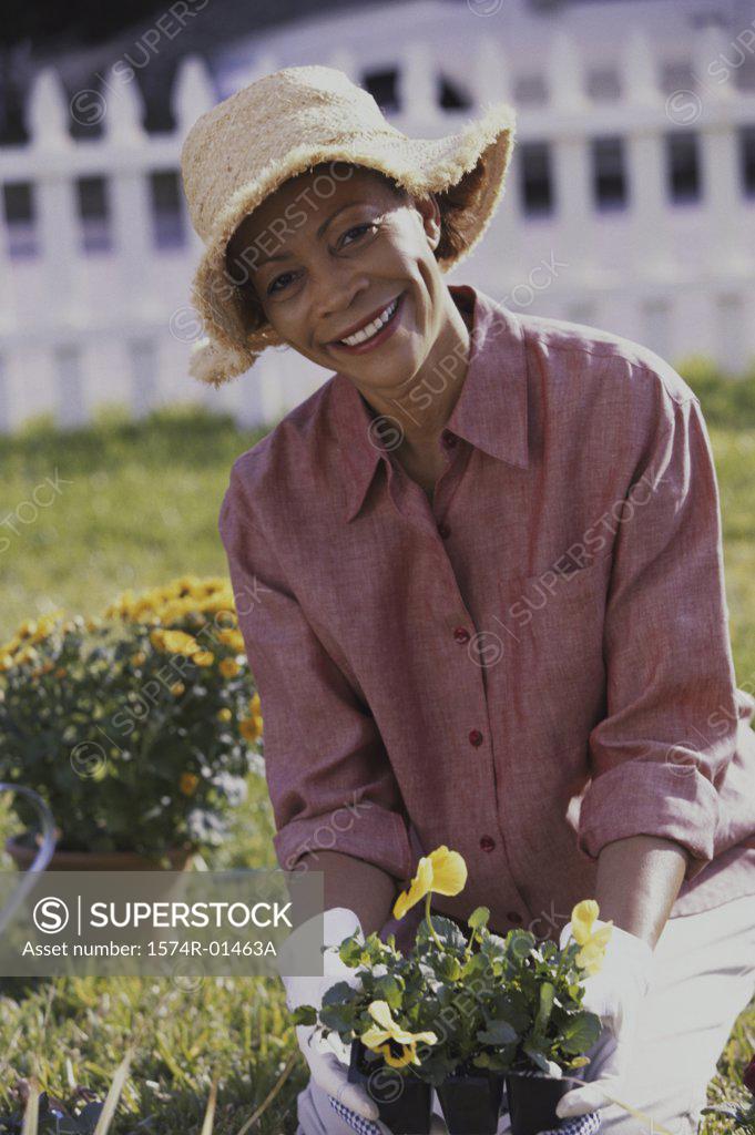 Stock Photo: 1574R-01463A Portrait of a senior woman holding potted plants