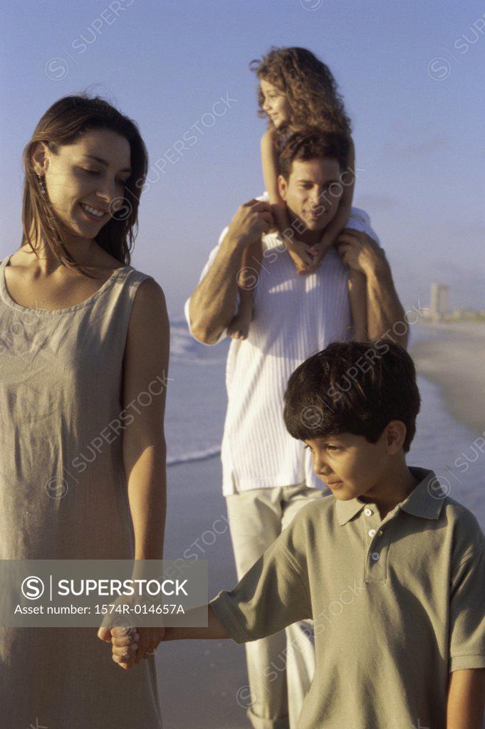 Stock Photo: 1574R-014657A Parents and their two children walking on the beach