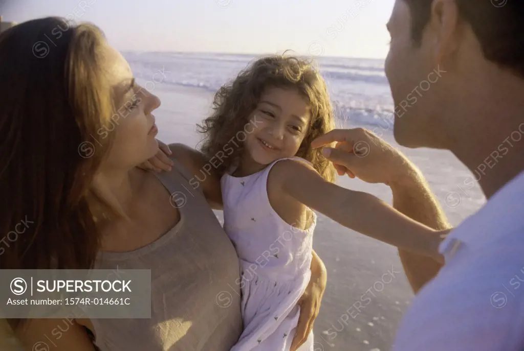 Close-up of parents with their daughter on the beach