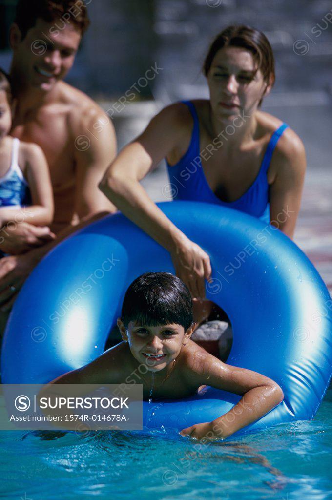 Stock Photo: 1574R-014678A Parents and their two children playing in a swimming pool