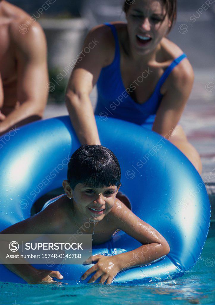 Stock Photo: 1574R-014678B Parents and their two children playing in a swimming pool