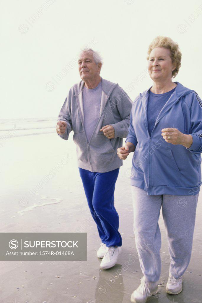 Stock Photo: 1574R-01468A Senior couple jogging at the beach