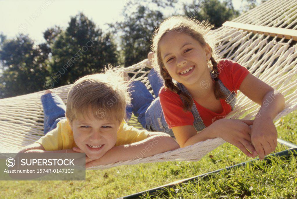 Stock Photo: 1574R-014710C Portrait of a girl and a boy lying in a hammock