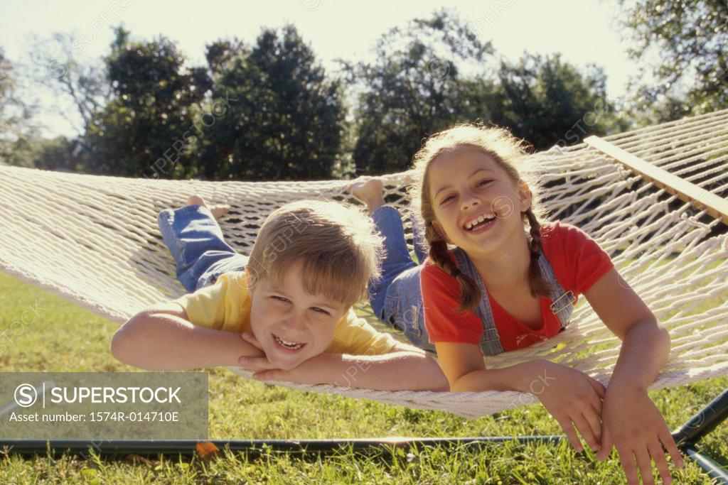 Stock Photo: 1574R-014710E Portrait of a girl and a boy lying in a hammock