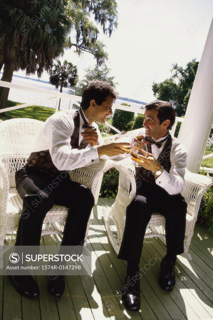 Stock Photo: 1574R-014729B Two mid adult men toasting with wineglasses