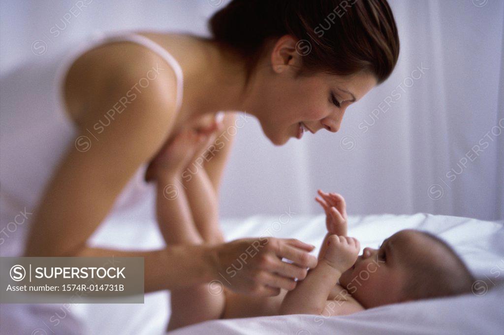 Stock Photo: 1574R-014731B Side profile of a mother playing with her baby boy