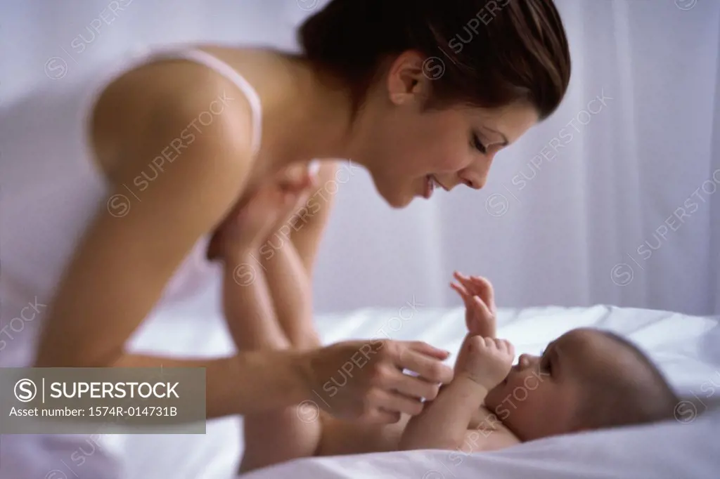Side profile of a mother playing with her baby boy