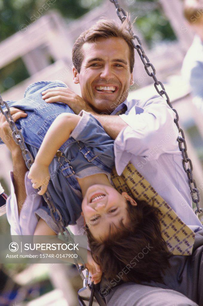 Stock Photo: 1574R-014790D Father sitting on a swing with his daughter
