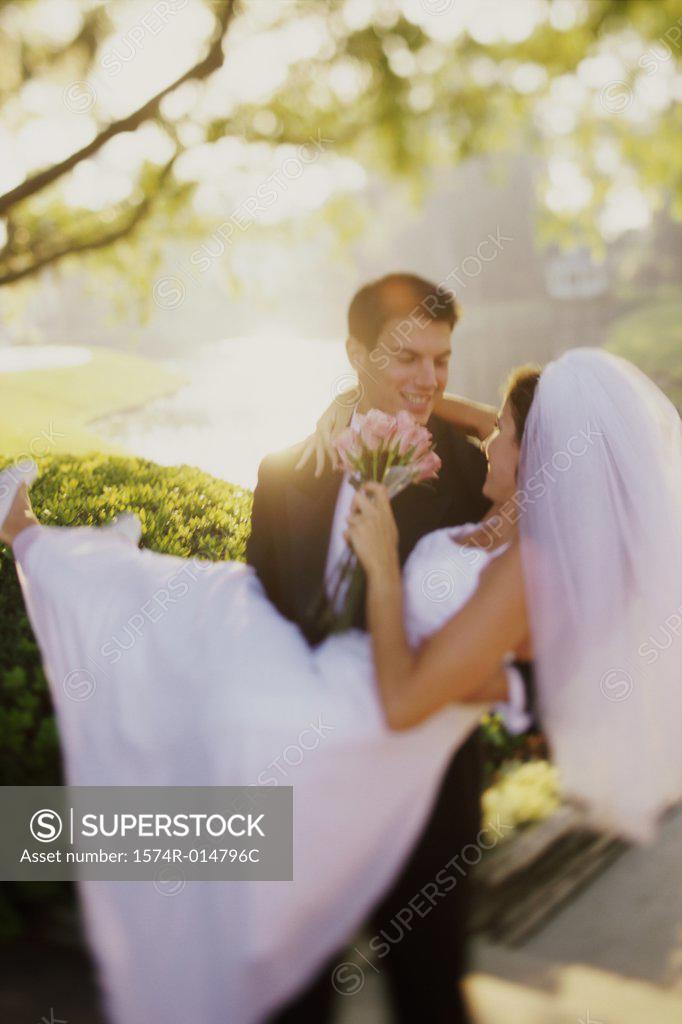 Stock Photo: 1574R-014796C Close-up of a groom carrying his bride