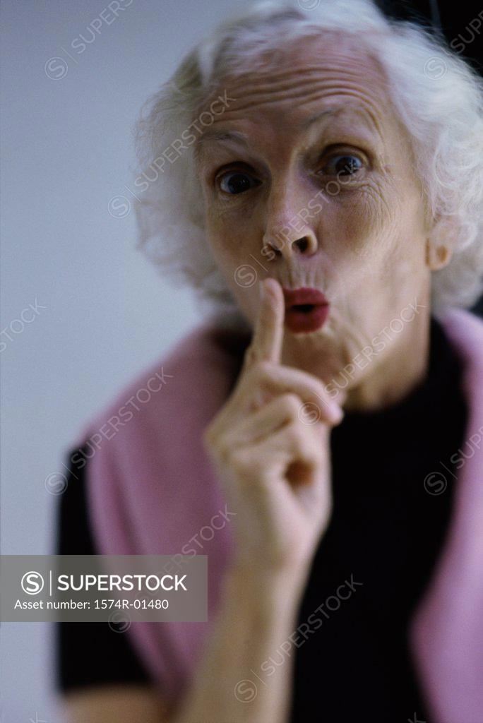 Stock Photo: 1574R-01480 Portrait of a senior woman holding her finger up to her lips