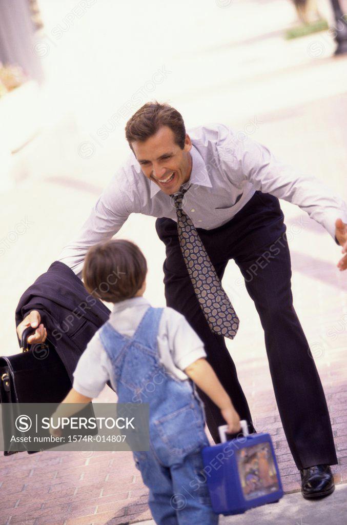 Stock Photo: 1574R-014807 Rear view of a son running towards his father