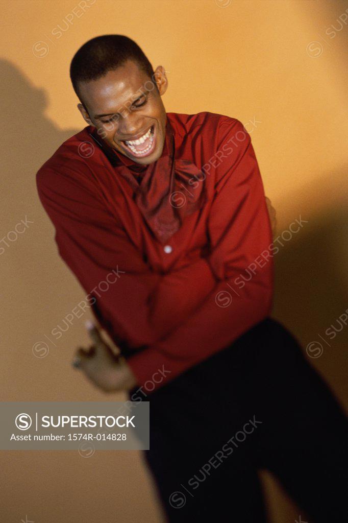 Stock Photo: 1574R-014828 High angle view of a young man laughing with his arms crossed