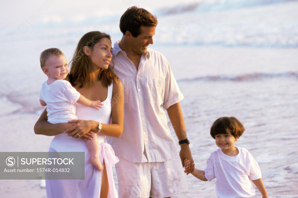Stock Photo: 1574R-014832 Parents and their two sons walking on the beach