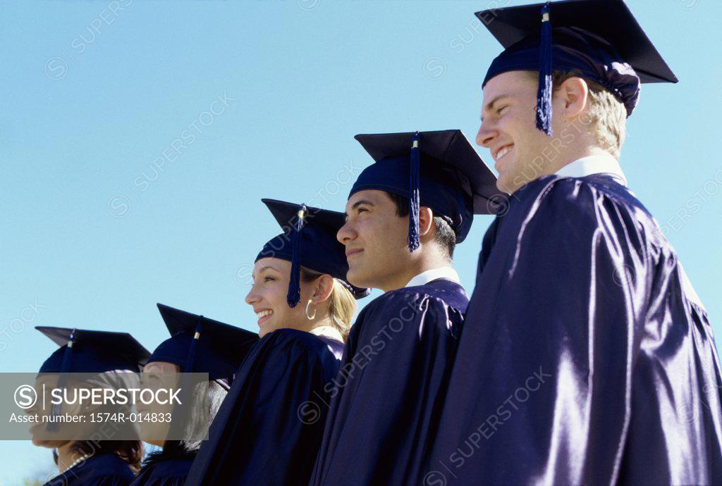 Stock Photo: 1574R-014833 Low angle view of five teenage graduates standing in a row