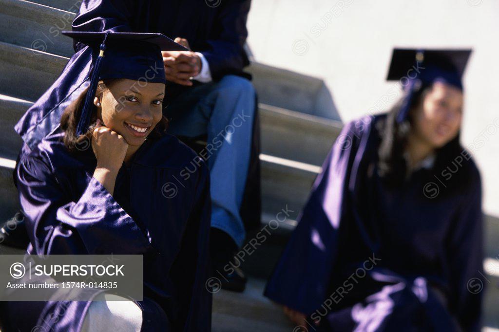 Stock Photo: 1574R-014835 Portrait of a teenage graduate girl sitting on steps and smiling