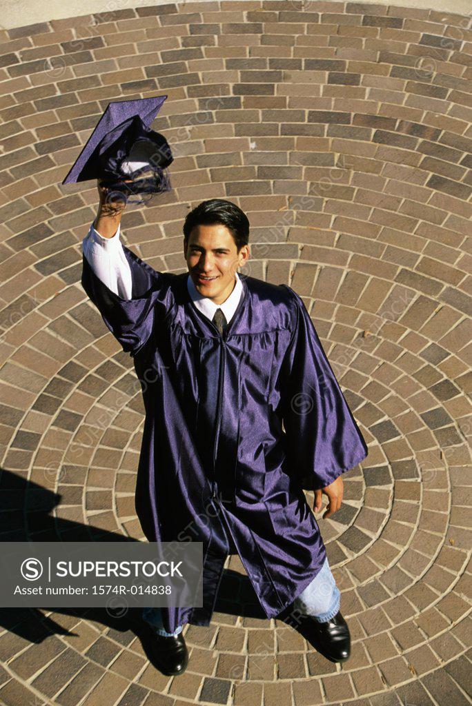 Stock Photo: 1574R-014838 High angle view of a teenage graduate boy raising his mortarboard