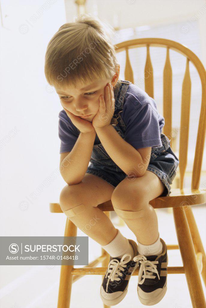 Stock Photo: 1574R-014841B Close-up of a boy sitting on a chair
