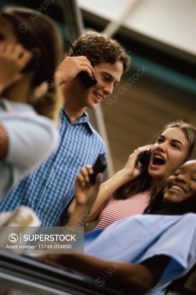 Stock Photo: 1574R-014850 Teenage girl and a teenage boy talking on mobile phones