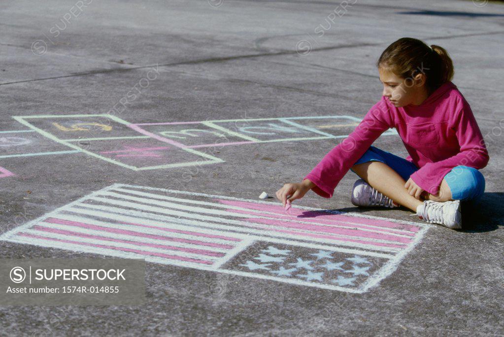 Stock Photo: 1574R-014855 High angle view of a girl drawing an American flag on the ground with chalk
