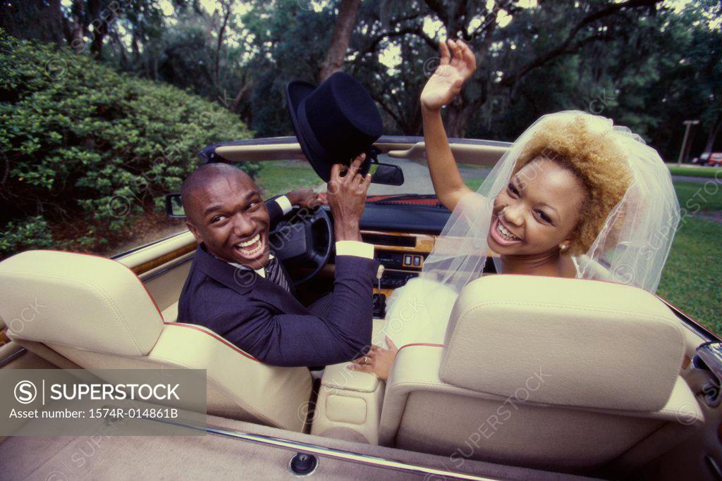 Stock Photo: 1574R-014861B Rear view of a newlywed couple sitting in a convertible car