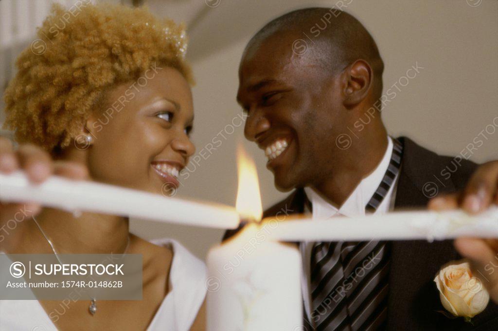 Stock Photo: 1574R-014862B Newlywed couple lighting candles