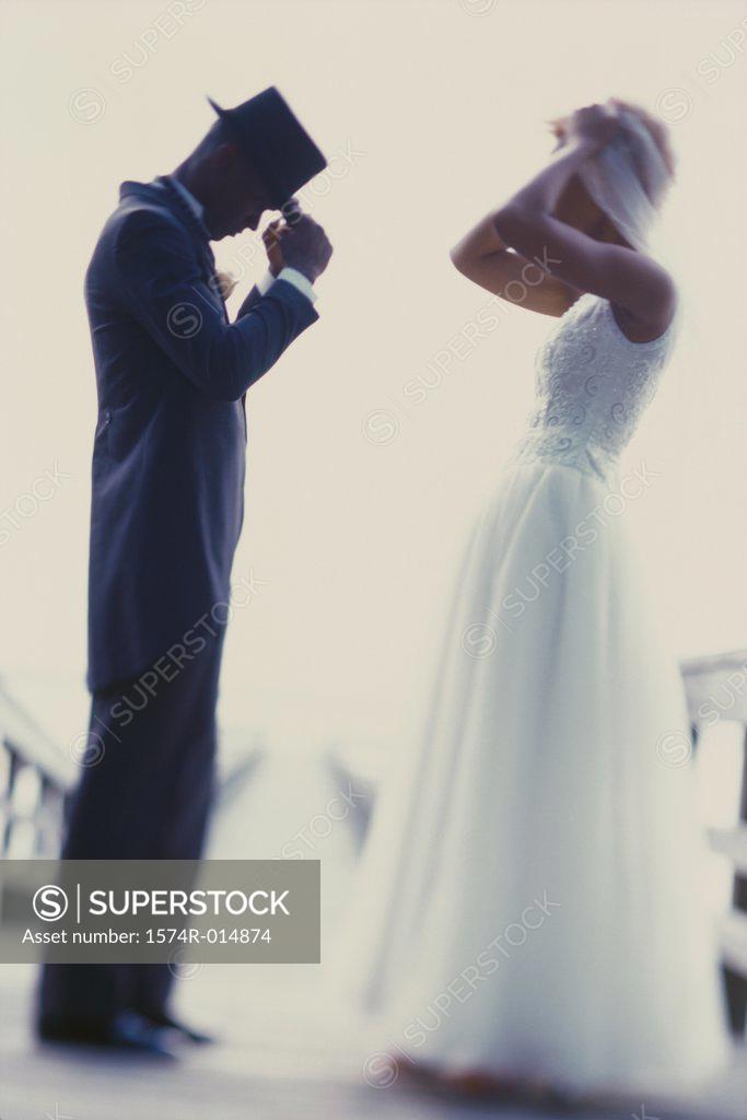 Stock Photo: 1574R-014874 Side profile of a newlywed couple adjusting their hats