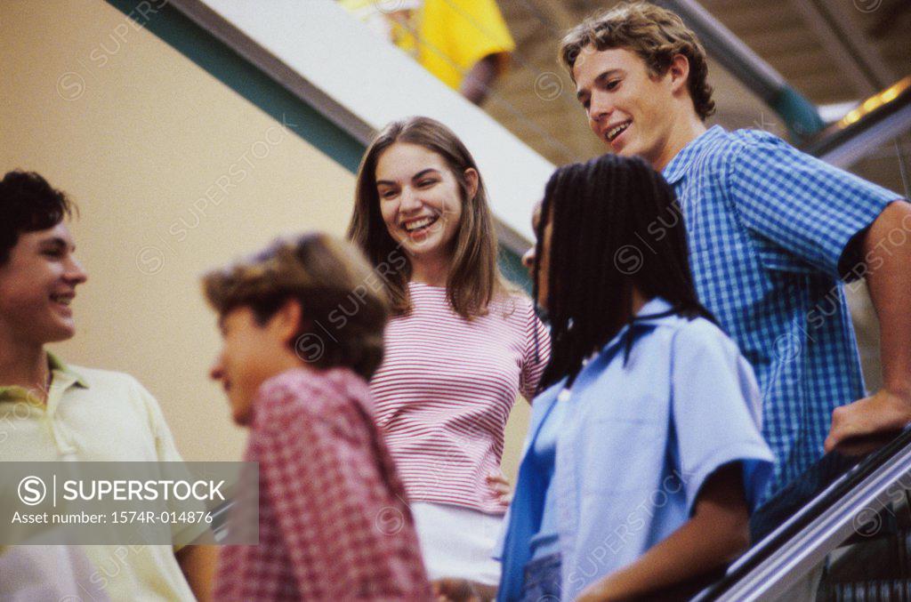 Stock Photo: 1574R-014876 Low angle view of two teenage girls and three teenage boys standing on an escalator