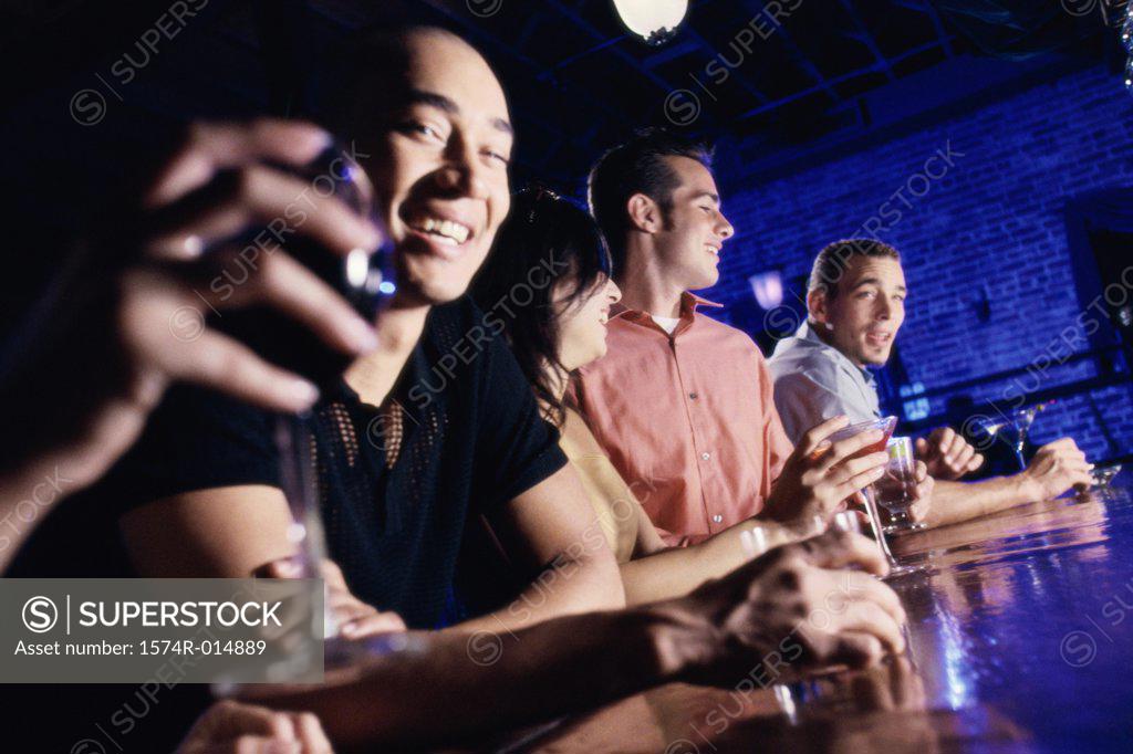 Stock Photo: 1574R-014889 Low angle view of four people at a bar smiling
