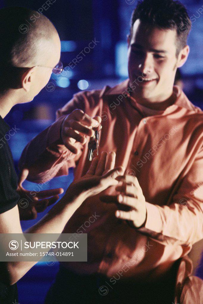 Stock Photo: 1574R-014891 Close-up of a young man giving a car key to his friend
