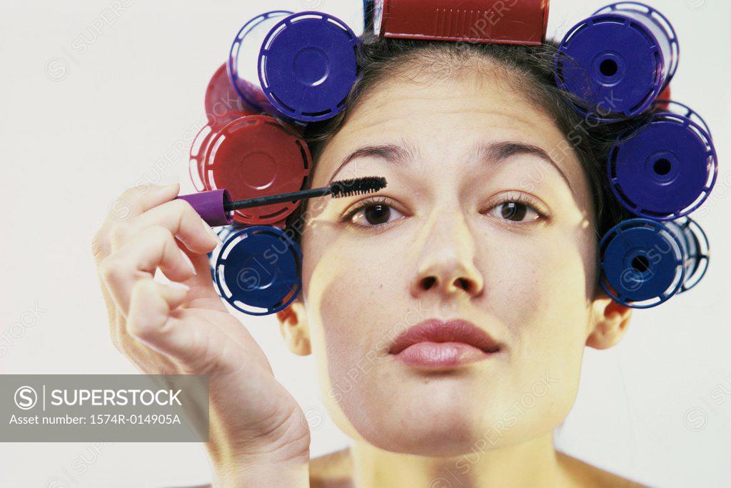Stock Photo: 1574R-014905A Portrait of a young woman applying mascara