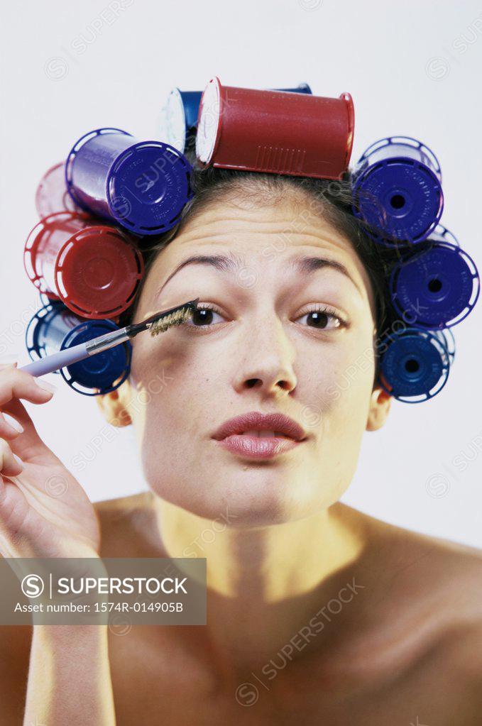 Stock Photo: 1574R-014905B Portrait of a young woman applying mascara
