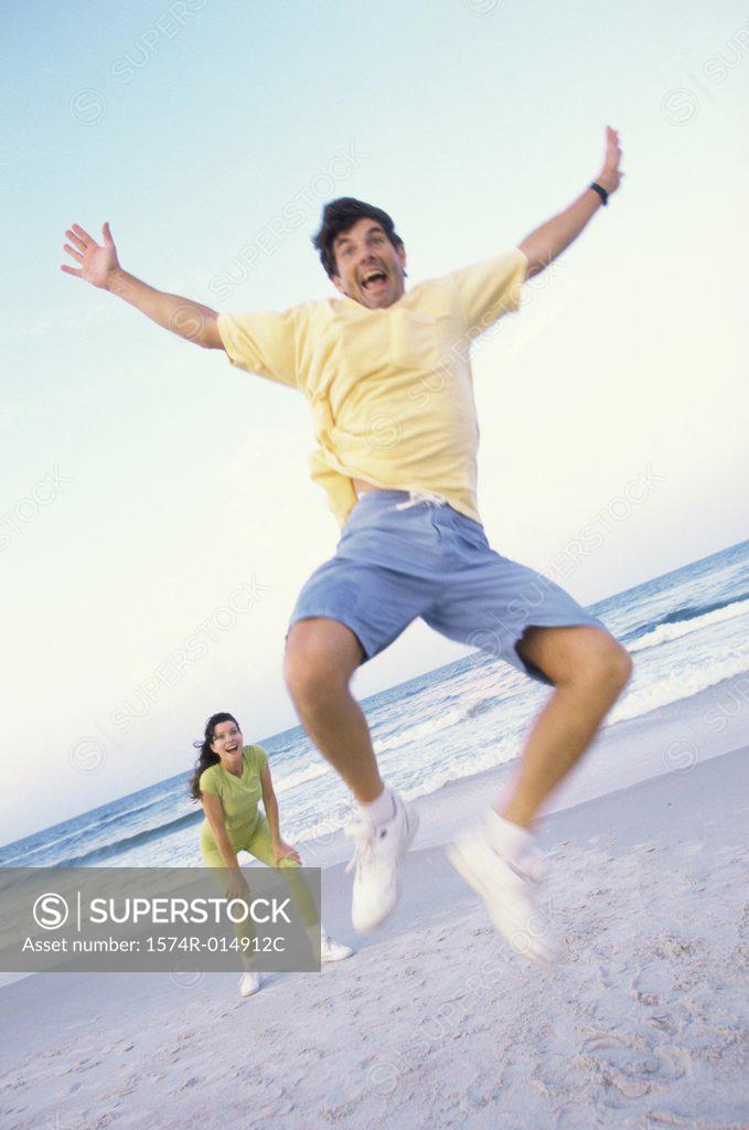Stock Photo: 1574R-014912C Low angle view of a mid adult man jumping on the beach