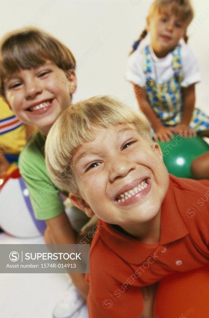 Stock Photo: 1574R-014913 Close-up of two boys and a girl smiling