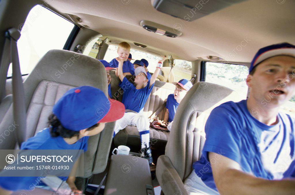 Stock Photo: 1574R-014930 Baseball players sitting with their coach in a van