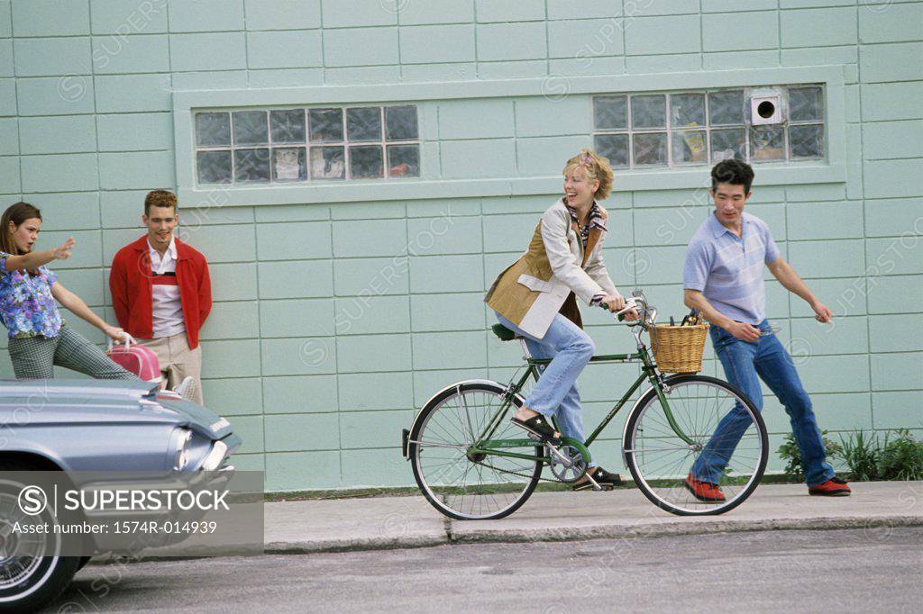 Stock Photo: 1574R-014939 Side profile of a young woman riding a bicycle and looking back