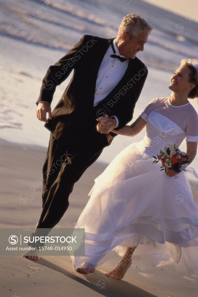 Stock Photo: 1574R-014950 Newlywed couple walking on the beach