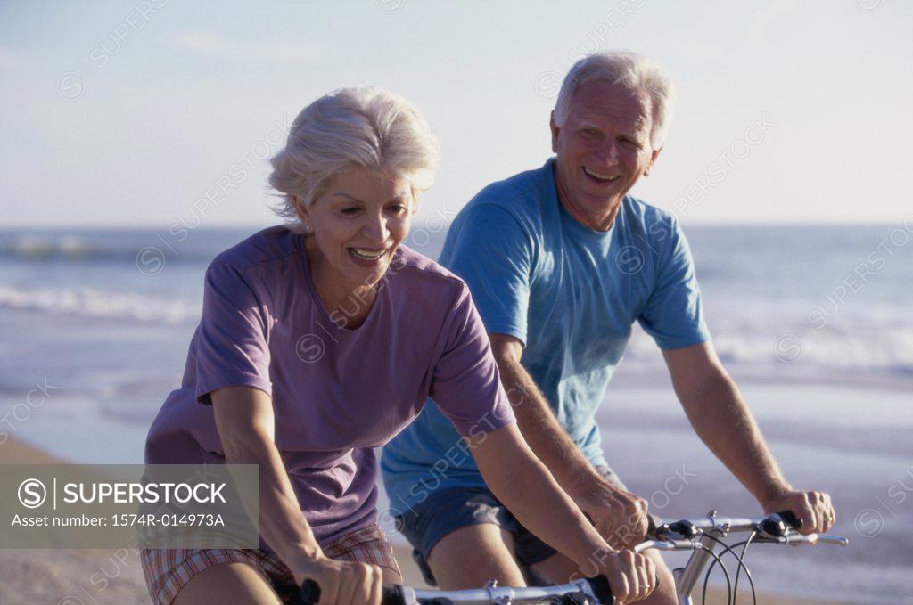 Stock Photo: 1574R-014973A Senior couple cycling on the beach
