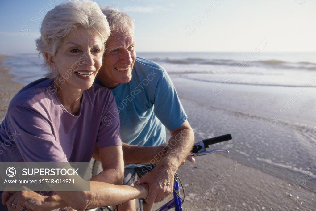 Stock Photo: 1574R-014974 Senior couple cycling on the beach