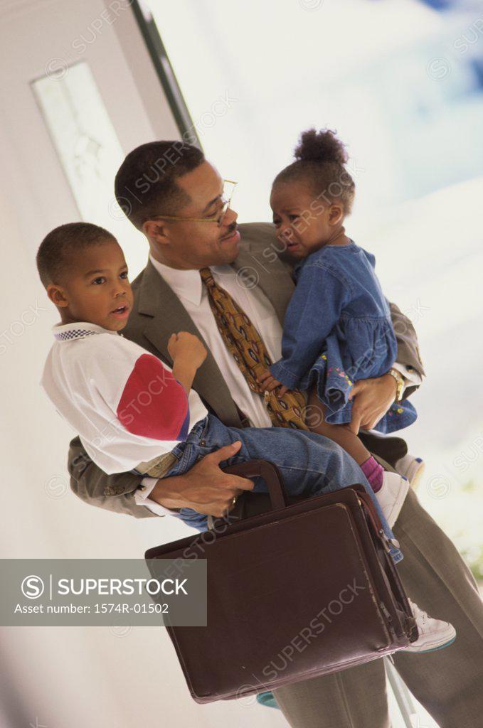 Stock Photo: 1574R-01502 Businessman carrying his son and daughter
