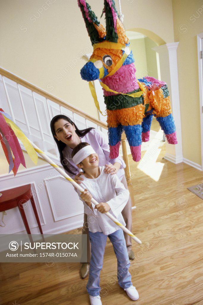 Stock Photo: 1574R-015074A High angle view of a mother helping her daughter hit a pinata