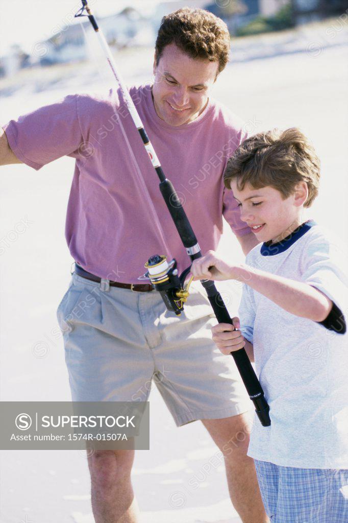 Stock Photo: 1574R-01507A Father and son fishing on the beach