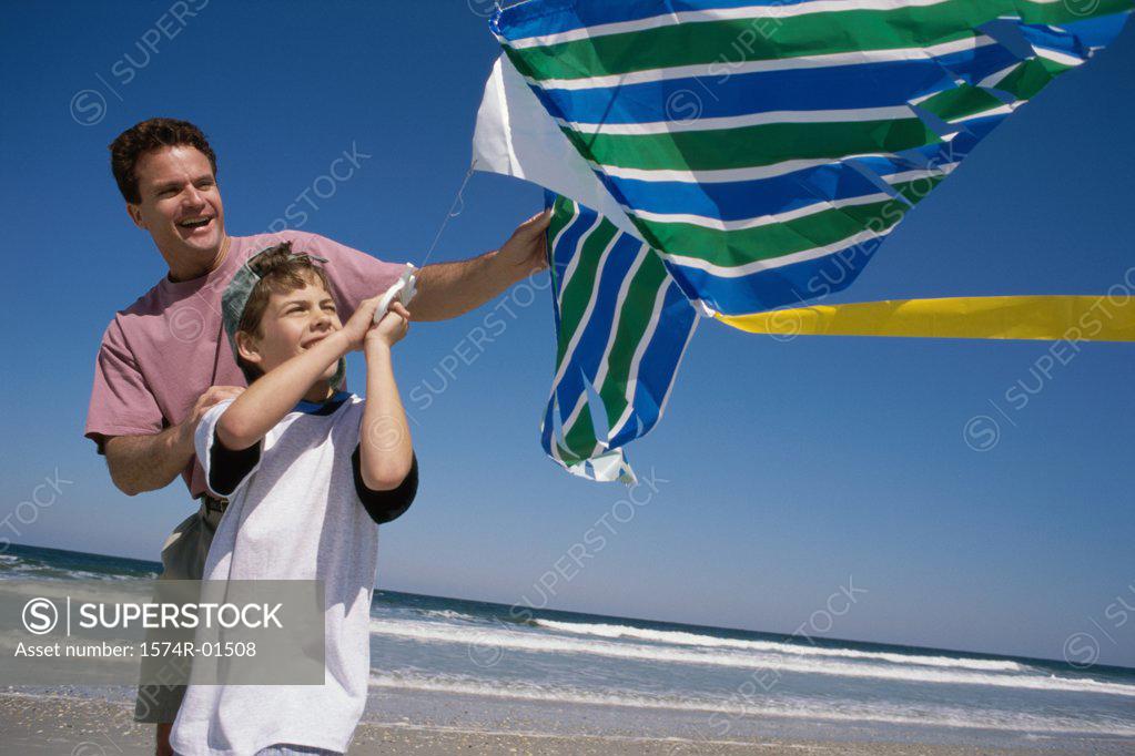 Stock Photo: 1574R-01508 Father and son flying a kite at the beach