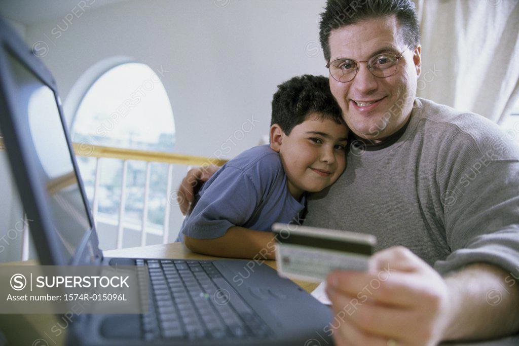 Stock Photo: 1574R-015096L Close-up of a father and son sitting in front of a laptop