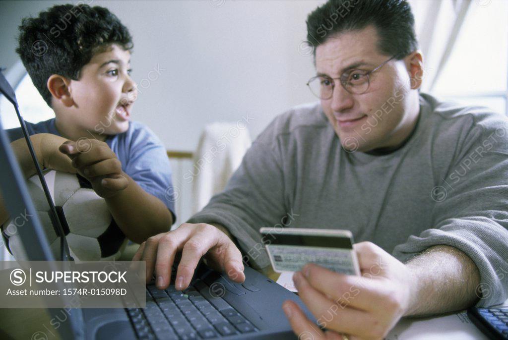Stock Photo: 1574R-015098D Close-up of a father and son sitting in front of a laptop