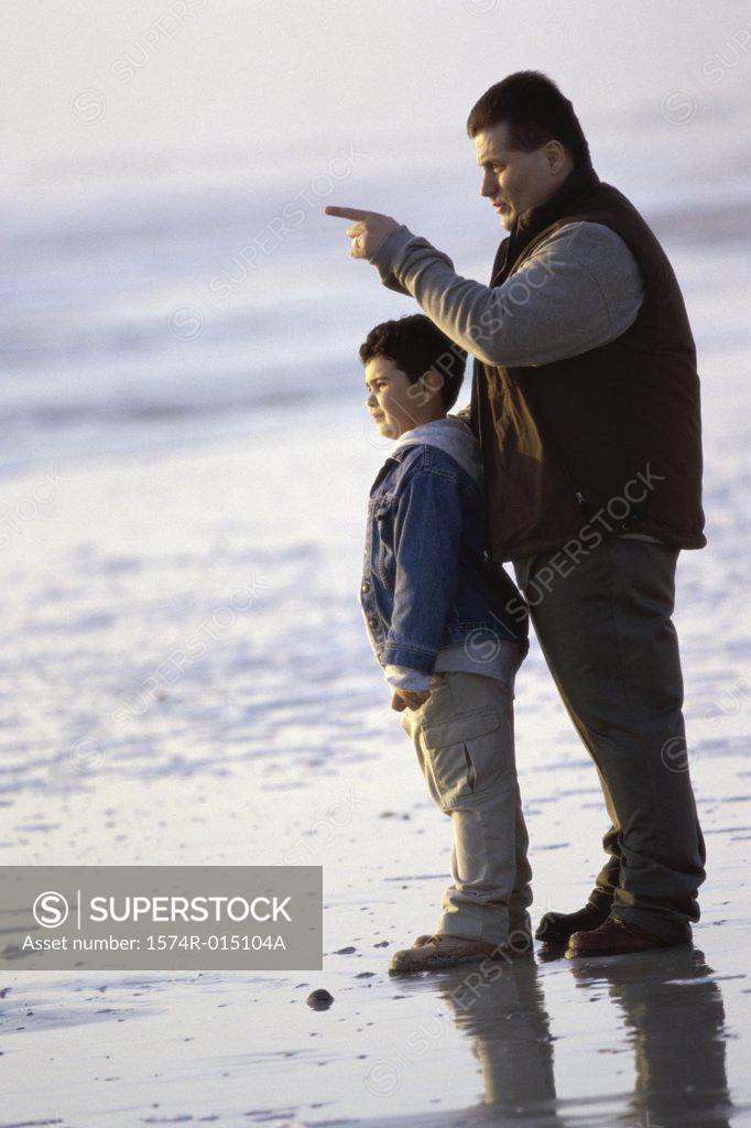 Stock Photo: 1574R-015104A Side profile of a father and son standing on the beach
