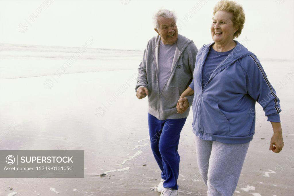 Stock Photo: 1574R-015105C Senior couple jogging on the beach
